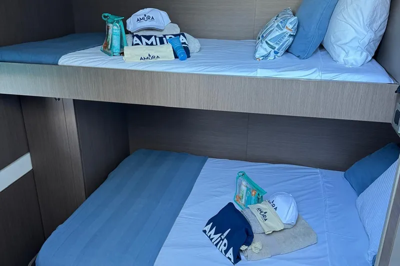 Amura Yacht Photos Pics Bali 5.4 Open Space 2021 yacht cabin with bunk beds and branded accessories.