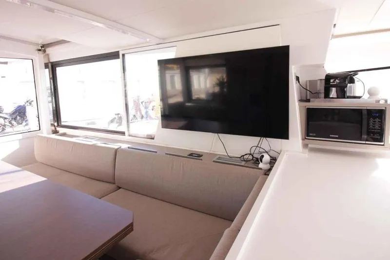 Amura Yacht Photos Pics Modern interior of 2021 Bali 5.4 Open Space yacht with TV, sofa, and kitchen appliances.