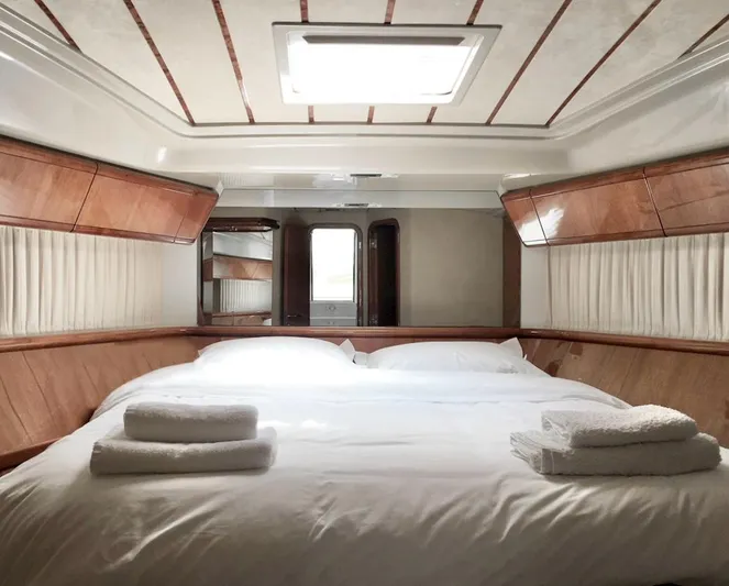 Ferretti 55 Yacht Photos Pics Luxurious bedroom interior of 1998 Ferretti Yachts FERRETTI 55 with elegant wood paneling.