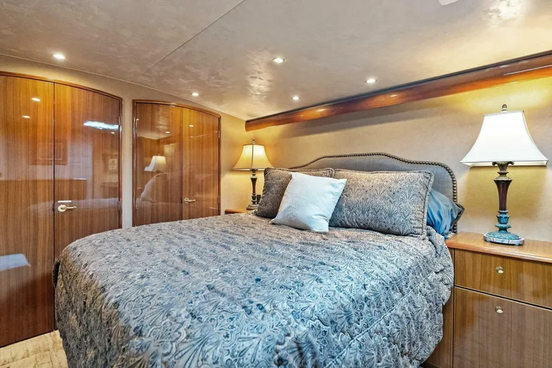 Knot On Call Yacht Photos Pics Luxurious bedroom interior of 2006 Viking 61 Convertible yacht with elegant bedding and warm lighting.