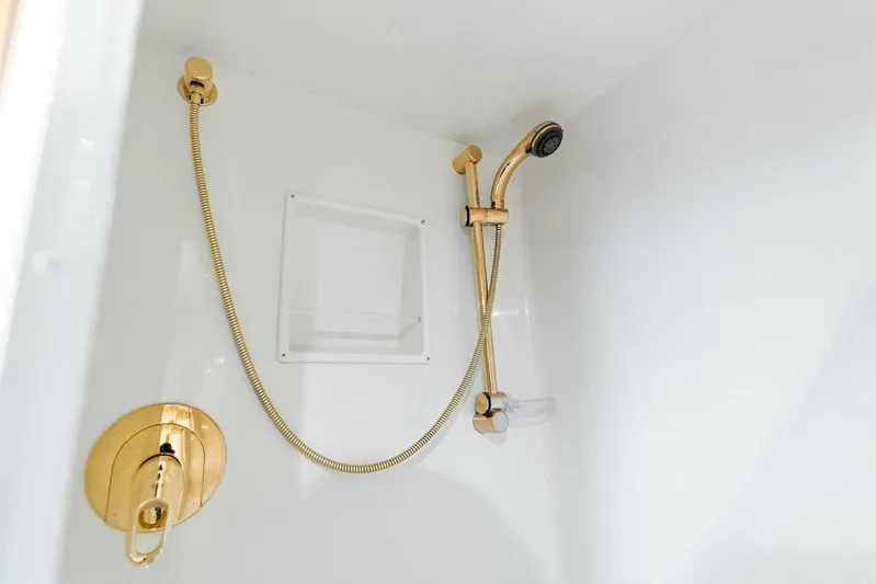 Knot On Call Yacht Photos Pics Luxurious gold shower fixtures in 2006 Viking 61 Convertible yacht bathroom.