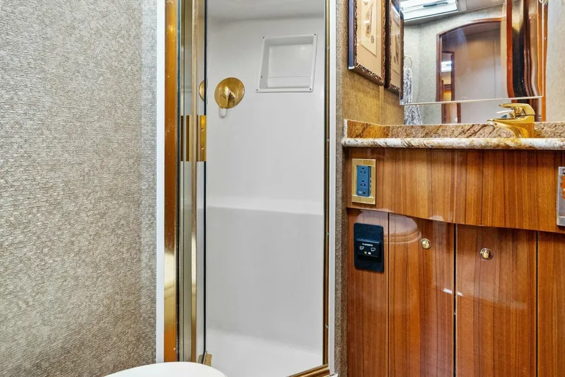 Knot On Call Yacht Photos Pics Luxurious bathroom interior of 2006 Viking 61 Convertible yacht with wood cabinetry and shower.