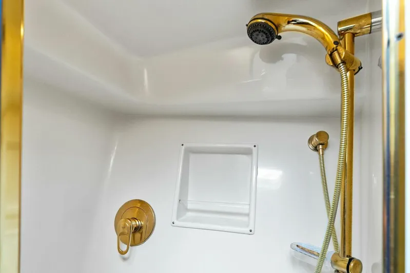 Knot On Call Yacht Photos Pics Luxurious gold shower fixtures in 2006 Viking 61 Convertible yacht bathroom.