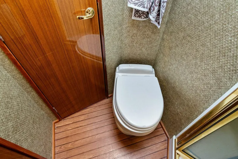 Knot On Call Yacht Photos Pics Luxurious bathroom in 2006 Viking 61 Convertible yacht with wooden door and modern toilet.