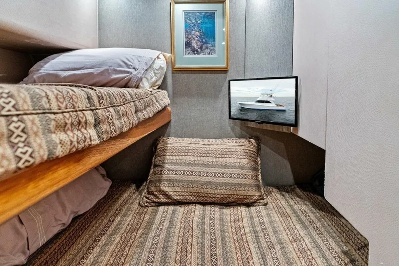 Knot On Call Yacht Photos Pics Cozy cabin interior of 2006 Viking 61 Convertible yacht with patterned bedding and wall-mounted TV.