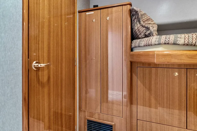 Knot On Call Yacht Photos Pics Interior of 2006 Viking 61 Convertible yacht with wooden cabinetry and patterned bedding.