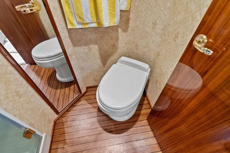 Knot On Call Yacht Photos Pics Luxurious bathroom in 2006 Viking 61 Convertible yacht with wooden flooring and elegant fixtures.