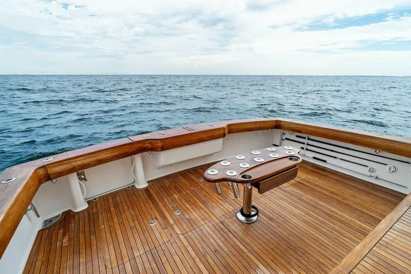 Knot On Call Yacht Photos Pics 2006 Viking 61 Convertible yacht deck with ocean view, featuring wooden flooring and rod holders.