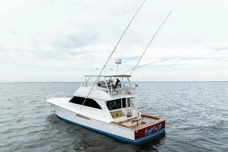 Knot On Call Yacht Photos Pics 2006 Viking 61 Convertible yacht on open water, featuring fishing rods and spacious deck.