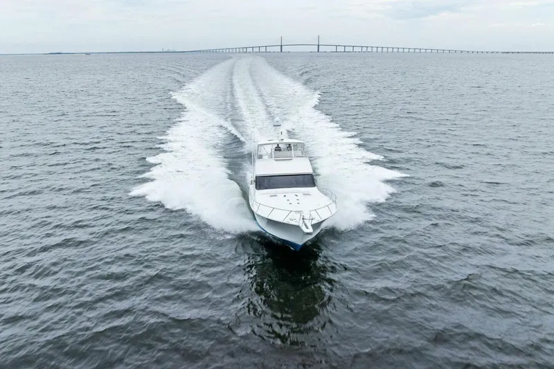 Knot On Call Yacht Photos Pics 2006 Viking 61 Convertible yacht cruising on open water with bridge in background.