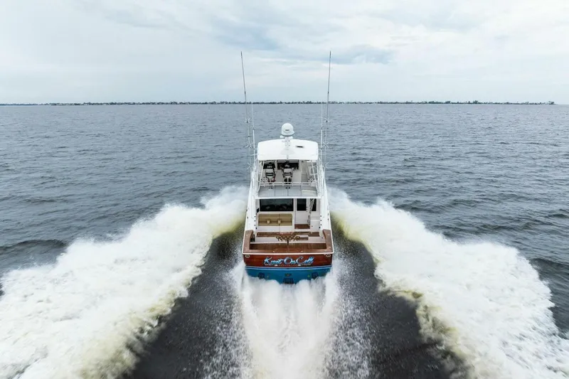 Knot On Call Yacht Photos Pics 2006 Viking 61 Convertible yacht cruising on open water, rear view.