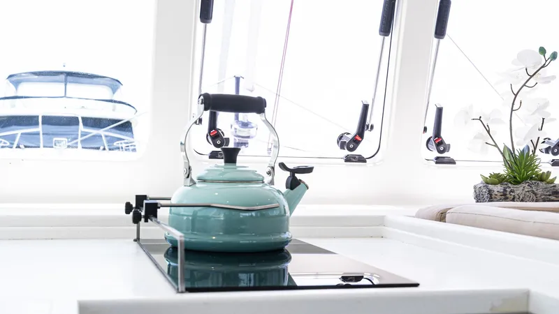 Nohea Yacht Photos Pics Teal kettle on stove in Custom Current Marine 46 yacht kitchen, 2022 model.