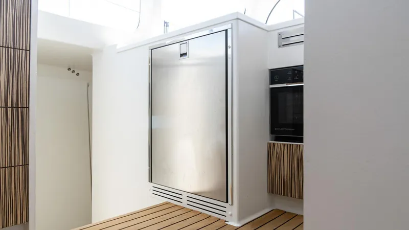 Nohea Yacht Photos Pics Modern kitchen interior on 2022 Custom Current Marine 46 yacht, featuring sleek appliances and wood accents.