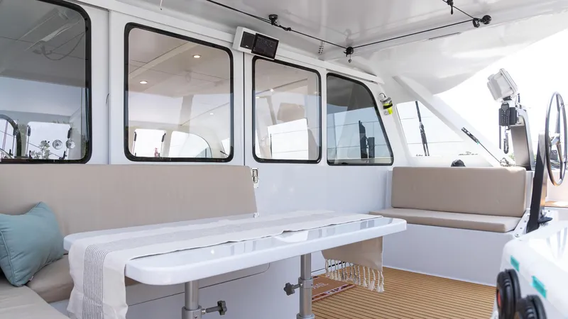 Nohea Yacht Photos Pics Spacious interior of 2022 Custom Current Marine 46 yacht with seating and table.
