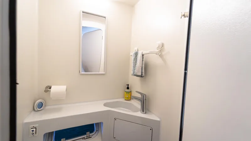 Nohea Yacht Photos Pics Modern bathroom in 2022 Custom Current Marine 46 yacht, featuring sleek sink and mirror.