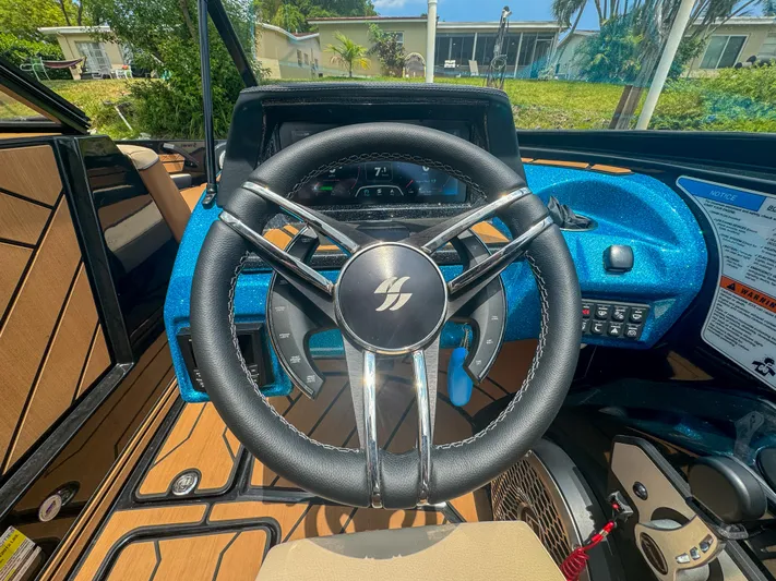  Yacht Photos Pics 2024 Varatti Z2373 boat steering wheel and dashboard in a sunny outdoor setting.