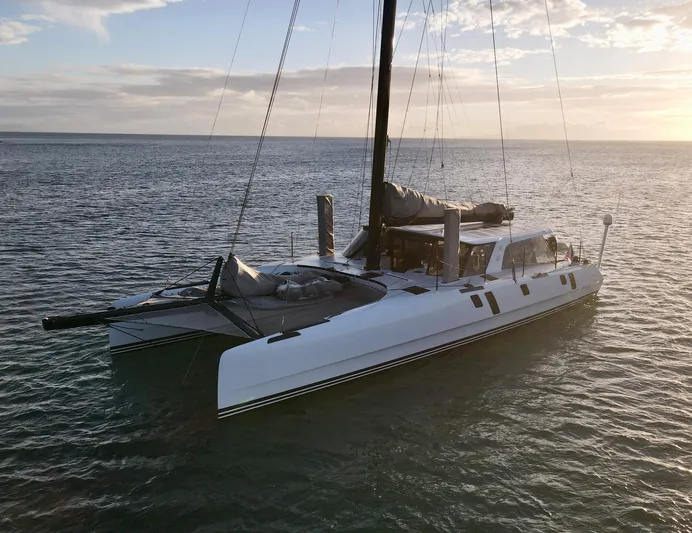 Cui Bono Yacht Photos Pics Gunboat 60 catamaran sailing on calm waters at sunset, 2015 model.