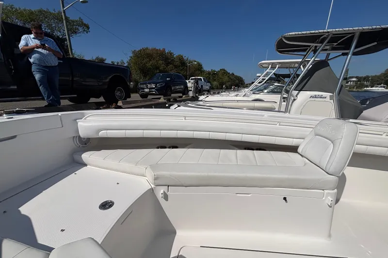  Yacht Photos Pics 2017 Regulator 28 boat interior with white seating, docked alongside other boats under clear blue sky.