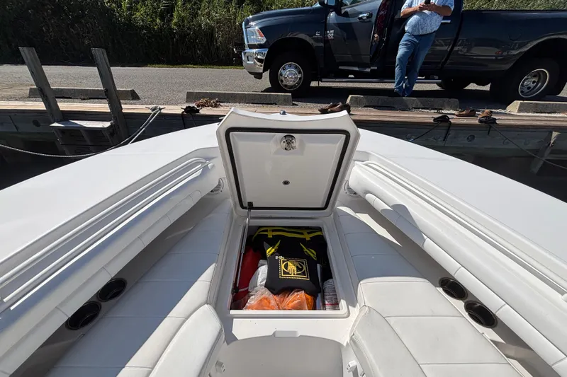  Yacht Photos Pics 2017 Regulator 28 boat with open storage compartment, docked near a pickup truck.
