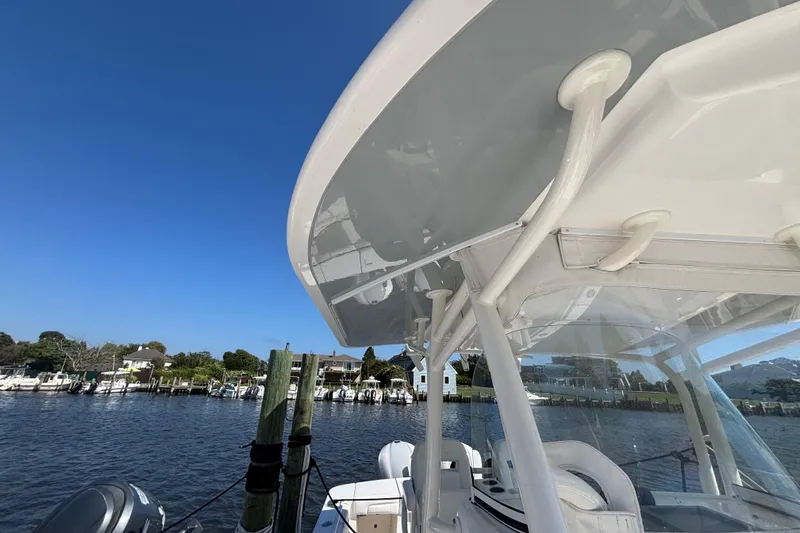  Yacht Photos Pics 2017 Regulator 28 boat with T-top, docked by a scenic waterfront.