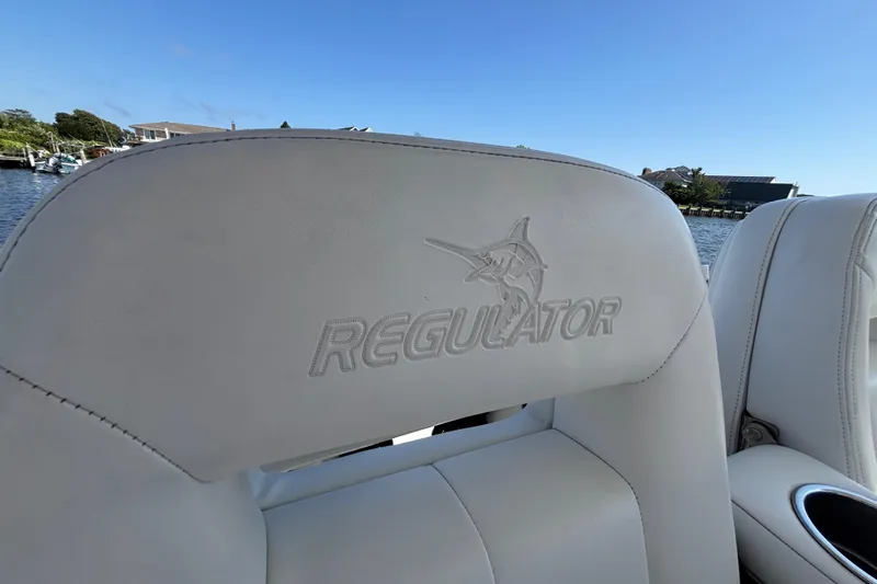  Yacht Photos Pics 2017 Regulator 28 boat seat with logo, overlooking a scenic waterfront.