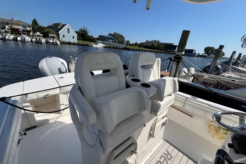  Yacht Photos Pics 2017 Regulator 28 boat with white seating, docked by waterfront homes.