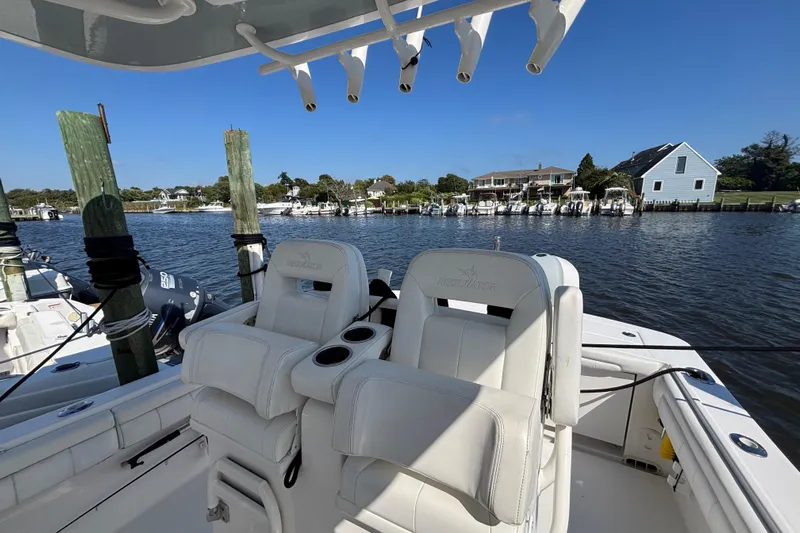  Yacht Photos Pics 2017 Regulator 28 boat with white seating, docked by waterfront homes.