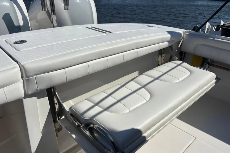  Yacht Photos Pics 2017 Regulator 28 boat with white cushioned seating and storage, docked by the water.