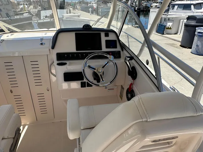  Yacht Photos Pics 2023 Grady-White Adventure 218 boat interior with steering wheel and control panel.