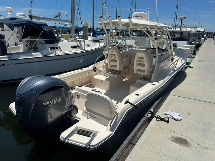  Yacht Photos Pics 2023 Grady-White Adventure 218 boat docked, featuring Yamaha outboard motor, in a sunny marina.