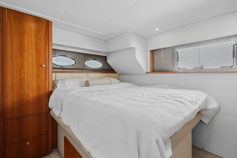  Yacht Photos Pics Luxurious bedroom interior of 2000 Silverton 392 Motor Yacht with cozy bed and wooden cabinetry.