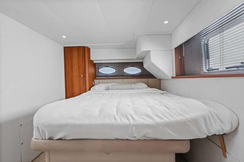  Yacht Photos Pics Luxurious bedroom interior of 2000 Silverton 392 Motor Yacht with cozy bed and wooden accents.