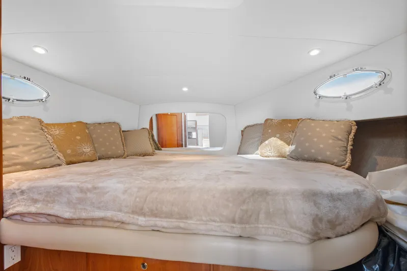  Yacht Photos Pics Luxurious interior cabin of a 2000 Silverton 392 Motor Yacht with plush bedding and porthole windows.