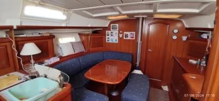  Yacht Photos Pics Interior of 2006 Beneteau Oceanis Clipper 393 yacht with wooden furnishings and blue seating.