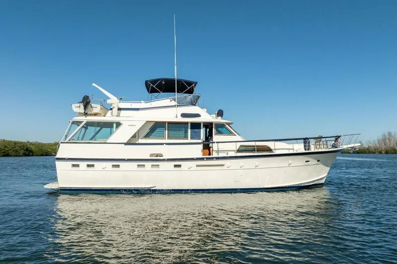 Even Keel Yacht Photos Pics 1985 Hatteras 53 Motor Yacht cruising on calm waters under clear blue sky.