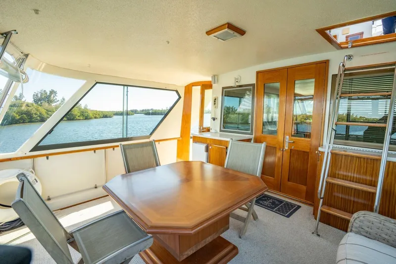 Even Keel Yacht Photos Pics 1985 Hatteras 53 Motor Yacht interior with dining area and scenic water view.