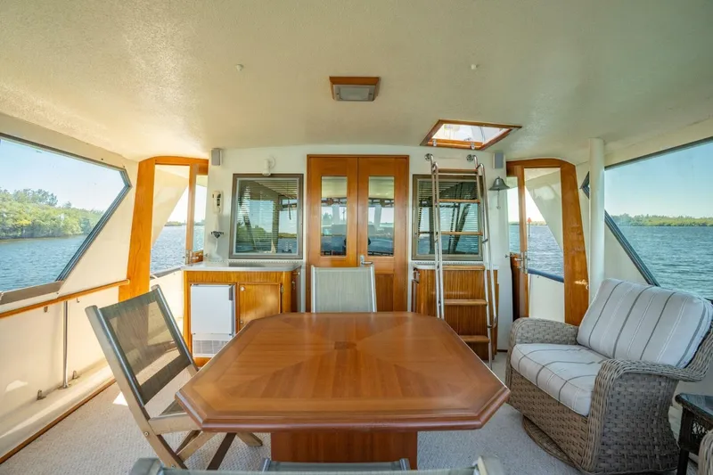 Even Keel Yacht Photos Pics Interior of 1985 Hatteras 53 Motor Yacht with elegant seating and wooden table.