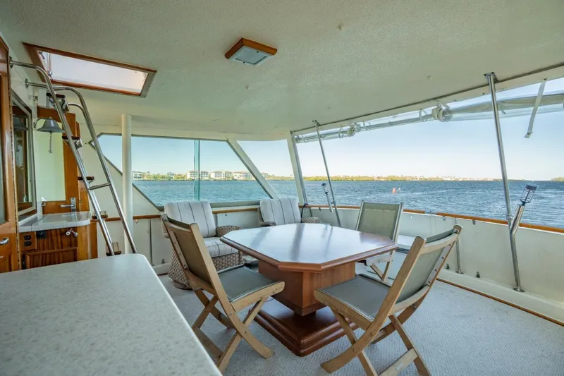Even Keel Yacht Photos Pics 1985 Hatteras 53 Motor Yacht interior with dining area overlooking serene water view.