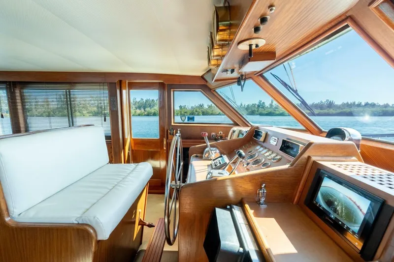 Even Keel Yacht Photos Pics Interior helm of 1985 Hatteras 53 Motor Yacht with panoramic windows and control panel.