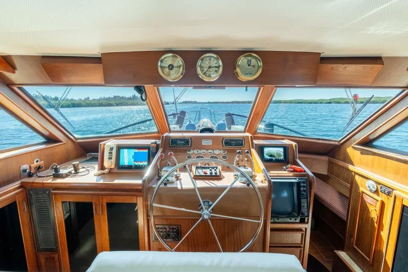 Even Keel Yacht Photos Pics Interior helm of 1985 Hatteras 53 Motor Yacht with navigational instruments and panoramic view.