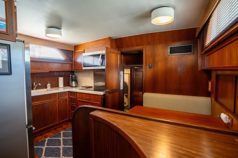 Even Keel Yacht Photos Pics Interior of 1985 Hatteras 53 Motor Yacht with wood paneling and modern kitchen amenities.