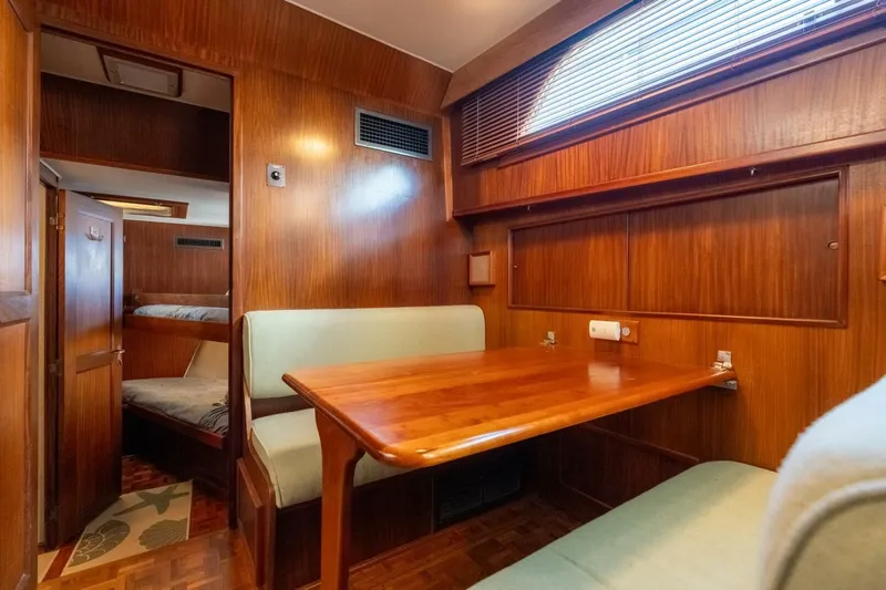 Even Keel Yacht Photos Pics 1985 Hatteras 53 Motor Yacht interior with wooden dining area and cozy seating.