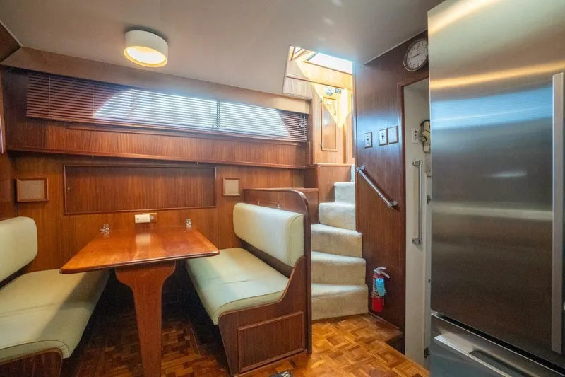 Even Keel Yacht Photos Pics 1985 Hatteras 53 Motor Yacht interior with dining area, wooden finishes, and staircase.