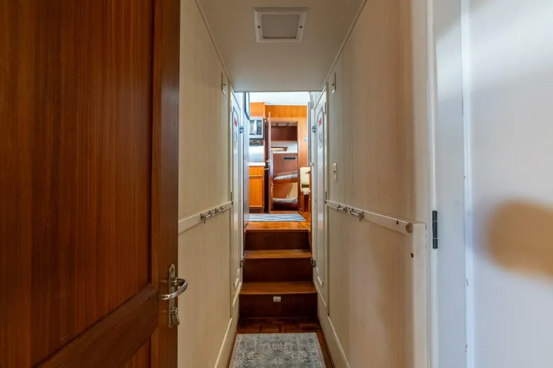 Even Keel Yacht Photos Pics Hallway inside 1985 Hatteras 53 Motor Yacht, featuring wooden doors and steps leading to cabin.