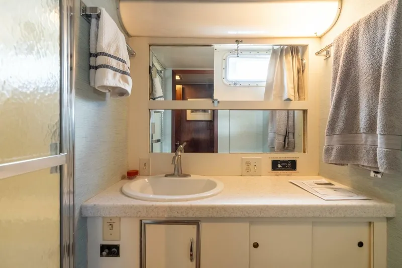 Even Keel Yacht Photos Pics Bathroom interior of 1985 Hatteras 53 Motor Yacht with sink, mirror, and towels.