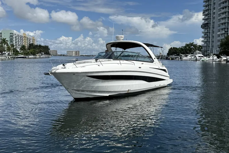  Yacht Photos Pics 2015 Sea Ray 370 Venture yacht on calm water, surrounded by buildings and palm trees.