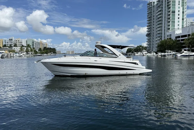  Yacht Photos Pics 2015 Sea Ray 370 Venture yacht on calm water near urban skyline.
