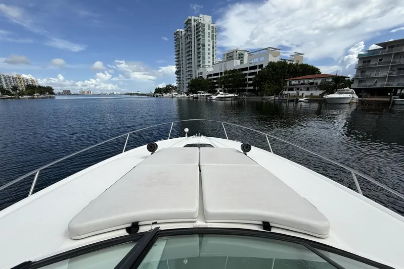  Yacht Photos Pics 2015 Sea Ray 370 Venture yacht cruising near waterfront buildings under a partly cloudy sky.