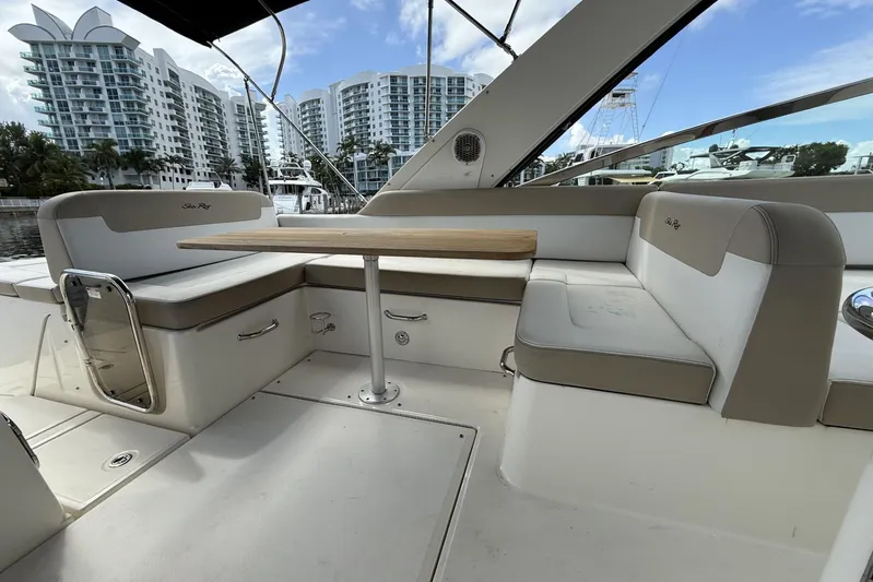  Yacht Photos Pics 2015 Sea Ray 370 Venture yacht interior with seating and table, docked near modern buildings.