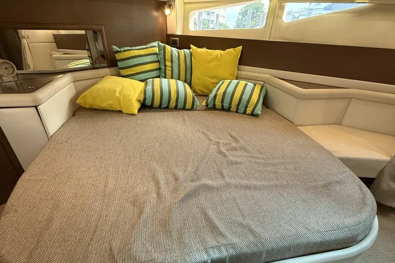  Yacht Photos Pics Cozy cabin interior of 2015 Sea Ray 370 Venture with striped and yellow pillows.